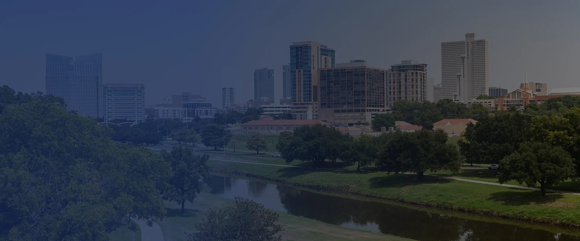 Downtown Fort Worth skyline with Trinity River and green park in the foreground