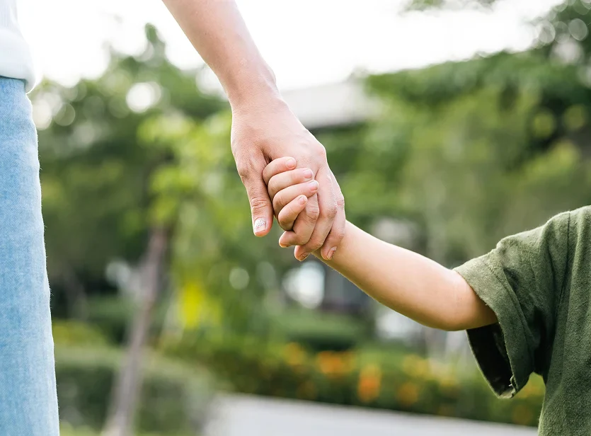 Parent holding a child’s hand symbolizing family support